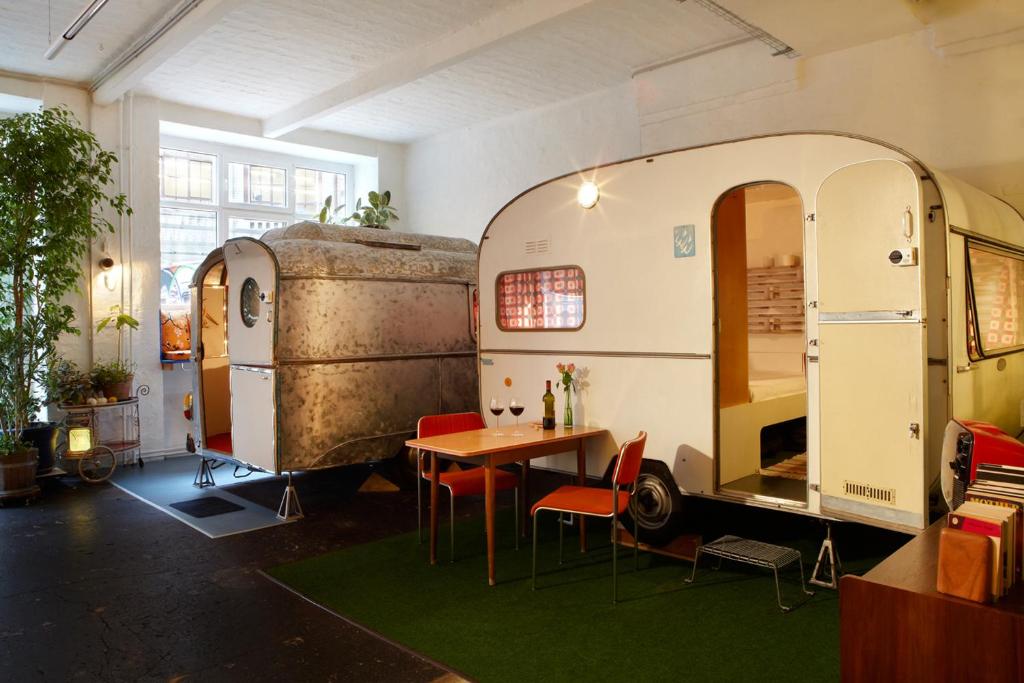 Wohnwagen und Holzhütten im Innenraum einer ehemaligen Fabrikhalle in Berlin-Neukölln